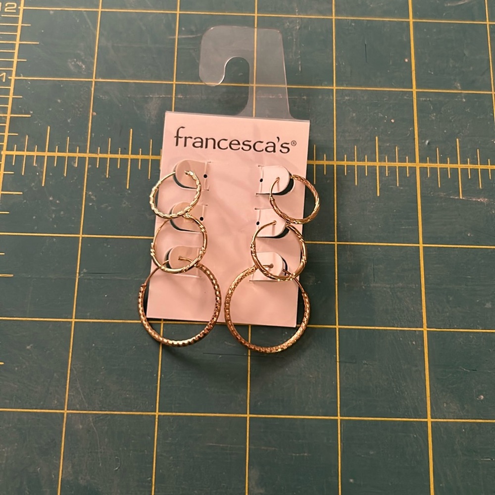 3 sets of gold hoop earrings.